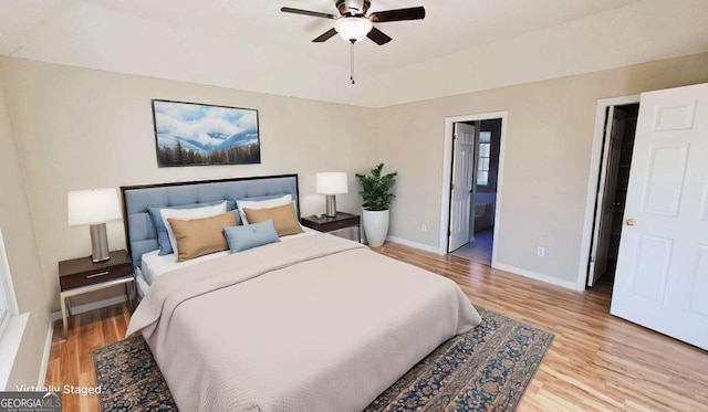 bedroom with ceiling fan, light hardwood / wood-style floors, and ensuite bath