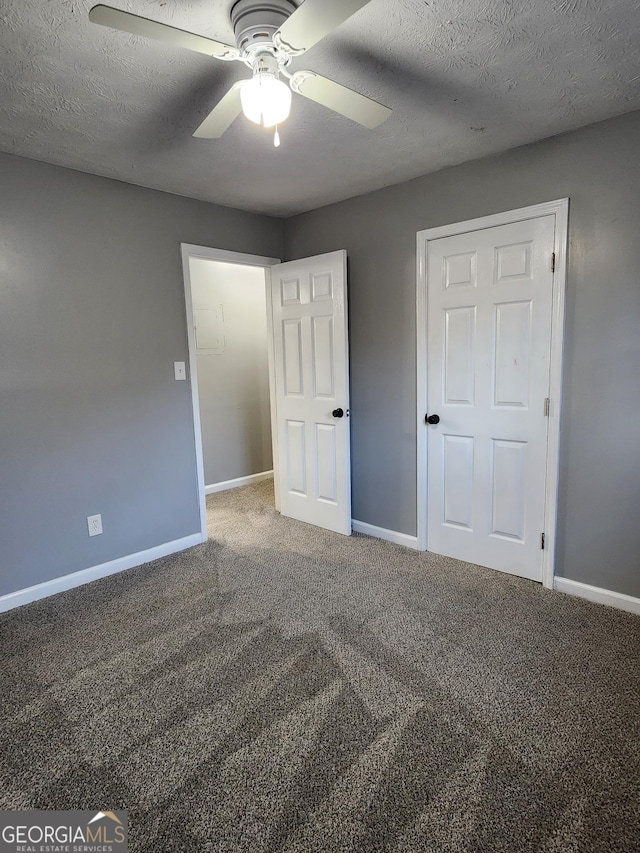 unfurnished bedroom featuring a textured ceiling, ceiling fan, and carpet flooring