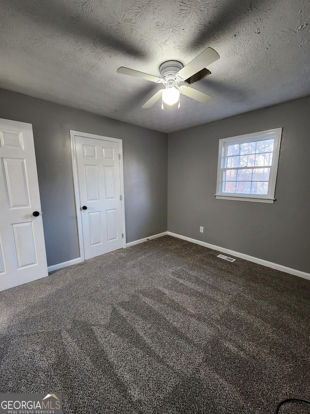 unfurnished bedroom featuring ceiling fan, carpet, and a textured ceiling