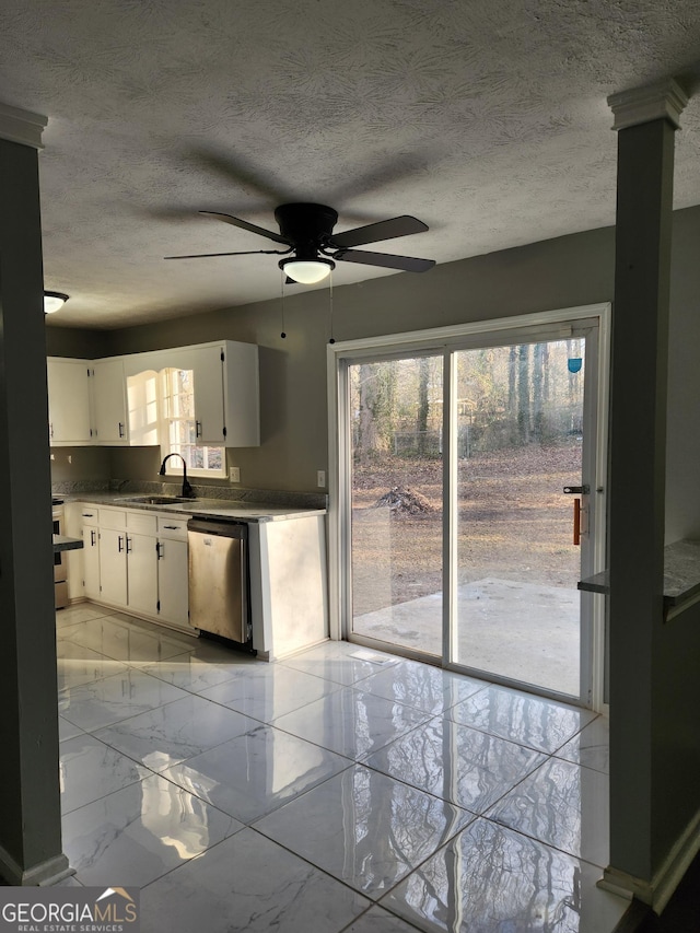 kitchen featuring sink, white cabinets, ceiling fan, stainless steel appliances, and a textured ceiling