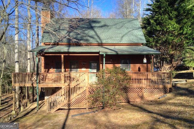 farmhouse featuring a wooden deck and covered porch