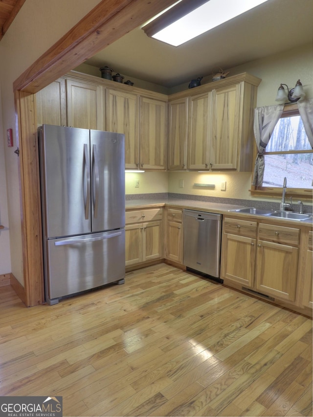 kitchen with sink, light brown cabinets, light hardwood / wood-style flooring, and stainless steel appliances