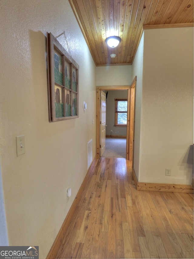 corridor featuring crown molding, wooden ceiling, and light hardwood / wood-style flooring