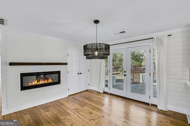 unfurnished dining area with crown molding and wood-type flooring