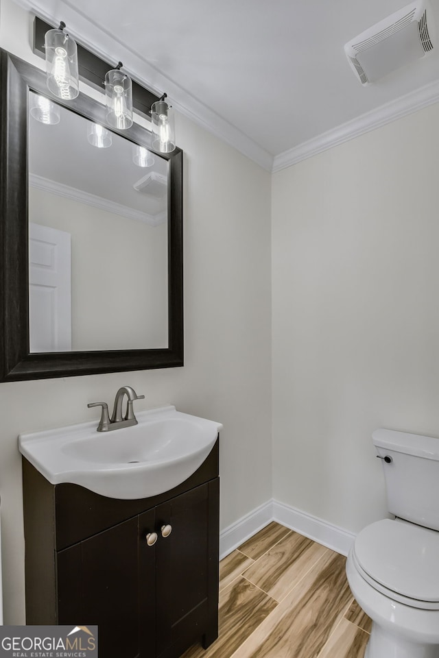 bathroom with crown molding, wood-type flooring, vanity, and toilet