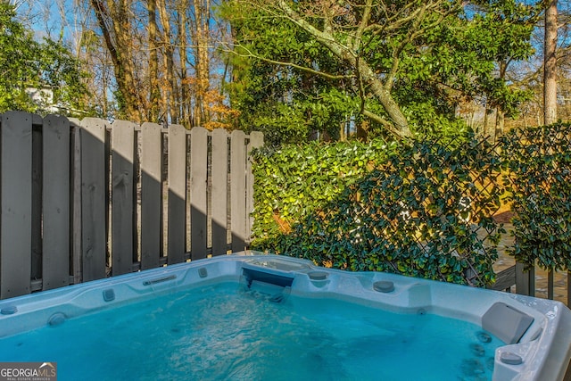 view of swimming pool featuring a hot tub