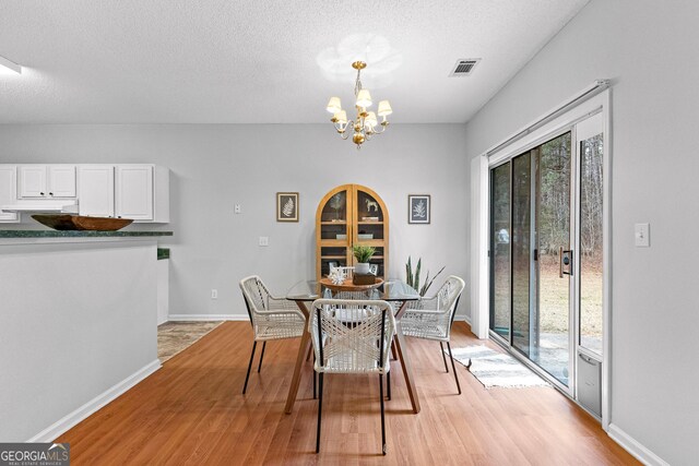 dining space featuring hardwood / wood-style floors and an inviting chandelier