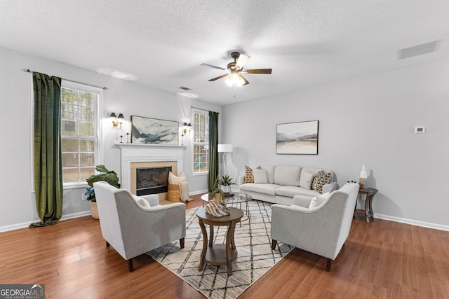 living room with a wealth of natural light, a textured ceiling, and light hardwood / wood-style floors