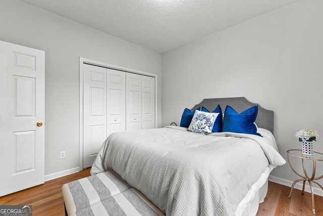 bedroom featuring hardwood / wood-style floors, a textured ceiling, and a closet