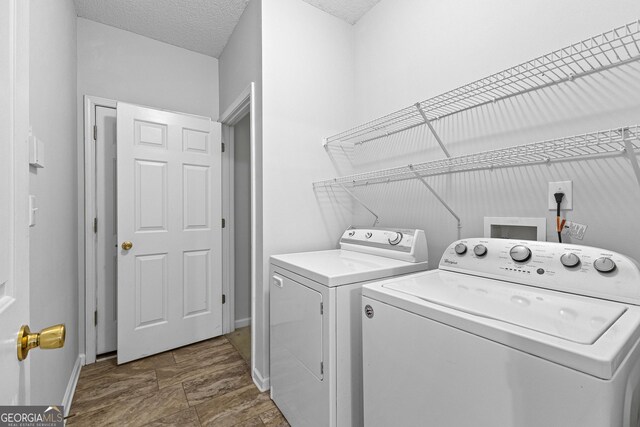 washroom featuring washer and dryer and a textured ceiling