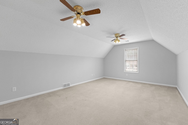 bonus room with light carpet, ceiling fan, vaulted ceiling, and a textured ceiling