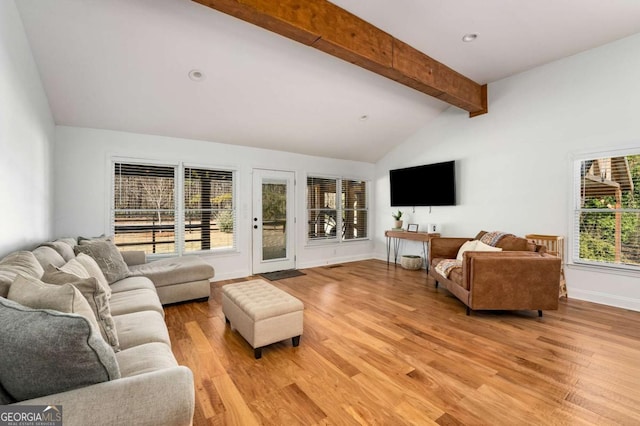 living room with light hardwood / wood-style floors and lofted ceiling with beams