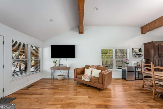 living room with light hardwood / wood-style flooring and lofted ceiling with beams