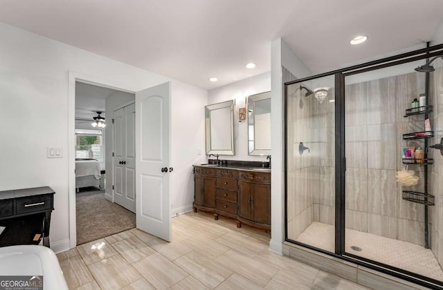 bathroom featuring a shower with shower door and vanity