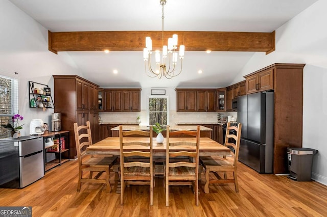 dining area with light hardwood / wood-style flooring, lofted ceiling with beams, a chandelier, and a healthy amount of sunlight