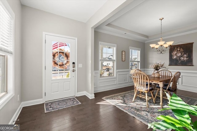 dining area featuring dark wood-type flooring, a notable chandelier, and a tray ceiling