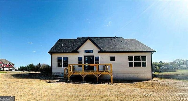 back of house featuring a deck and a yard