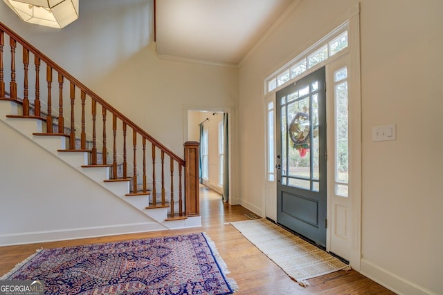 entrance foyer with wood-type flooring and crown molding