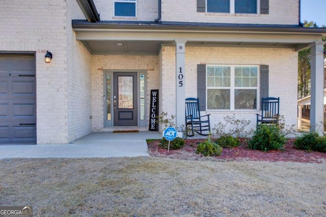 property entrance featuring covered porch and a garage