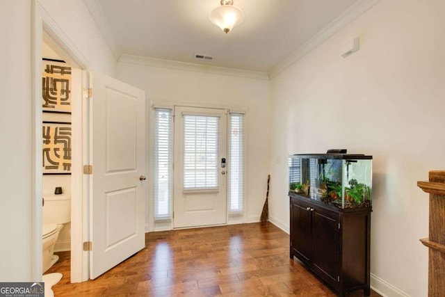 entryway with wood-type flooring and crown molding