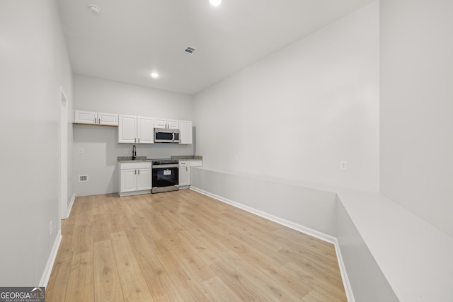 interior space with light hardwood / wood-style floors, white cabinetry, and appliances with stainless steel finishes