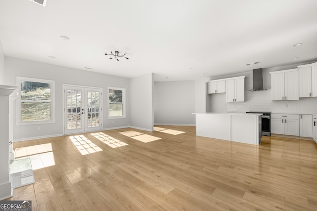 unfurnished living room featuring light hardwood / wood-style flooring and french doors