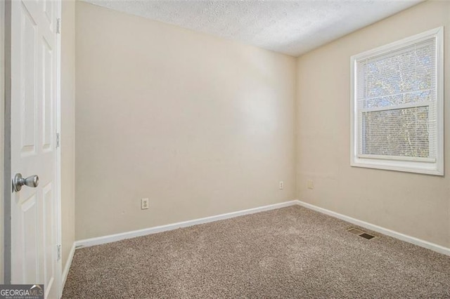 spare room featuring carpet and a textured ceiling