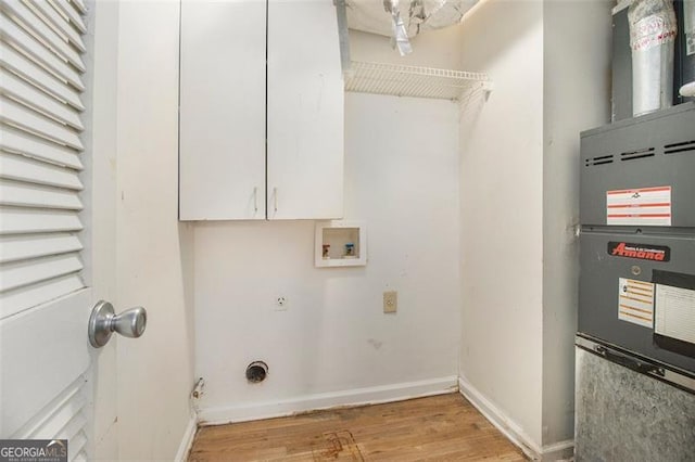 clothes washing area featuring light hardwood / wood-style flooring, cabinets, hookup for a washing machine, hookup for an electric dryer, and heating unit