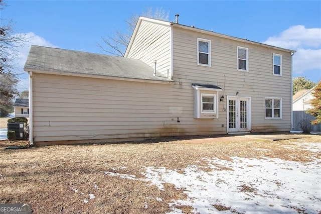 snow covered back of property with french doors