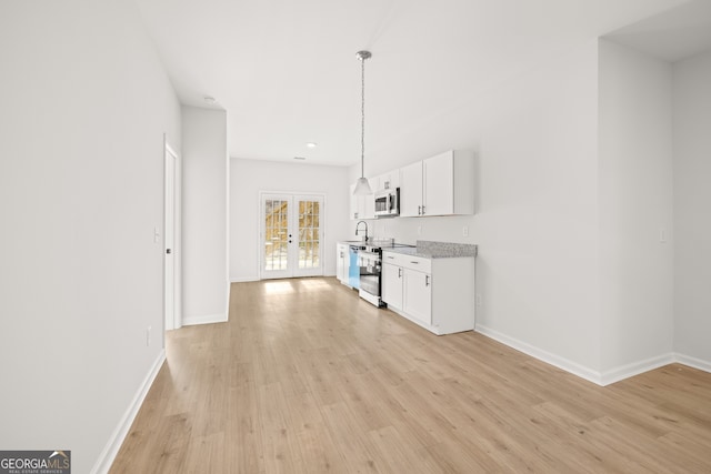 kitchen with hanging light fixtures, french doors, appliances with stainless steel finishes, white cabinets, and light hardwood / wood-style floors