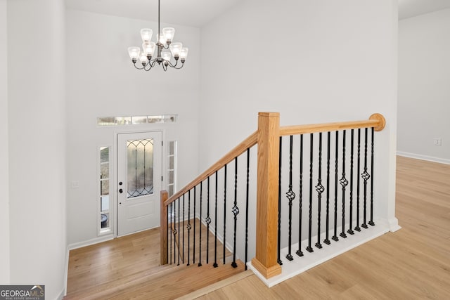 foyer with a notable chandelier and wood-type flooring