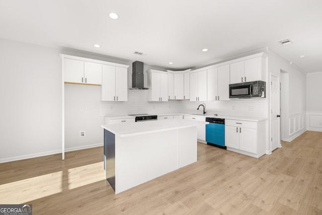 kitchen with a center island, light hardwood / wood-style floors, stainless steel dishwasher, white cabinets, and wall chimney exhaust hood