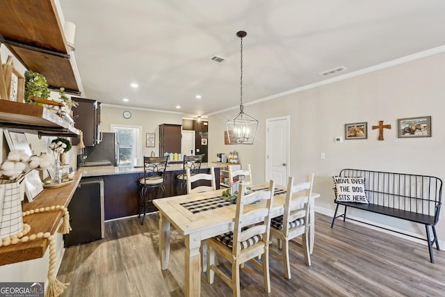 dining room with crown molding, dark hardwood / wood-style floors, and a notable chandelier