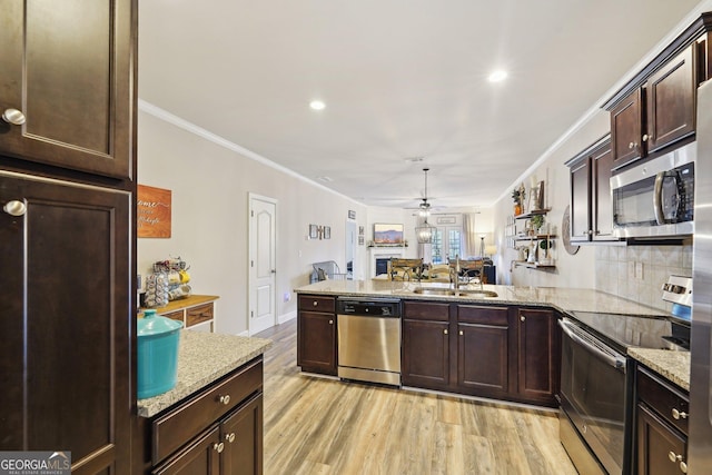 kitchen featuring kitchen peninsula, ceiling fan, sink, light hardwood / wood-style floors, and stainless steel appliances