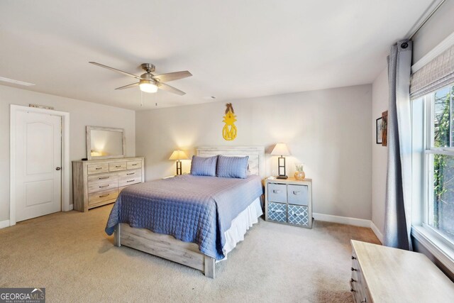 bedroom with light carpet, multiple windows, and ceiling fan