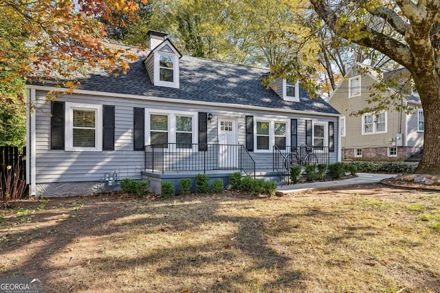 cape cod house featuring a front lawn