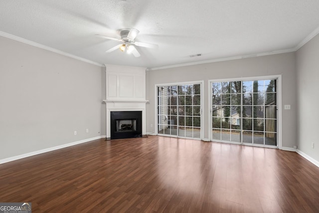 unfurnished living room with crown molding, a fireplace, a textured ceiling, wood finished floors, and baseboards