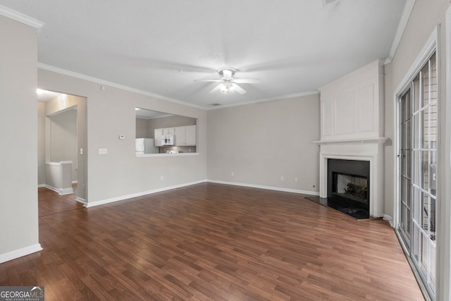 unfurnished living room featuring a fireplace, baseboards, dark wood finished floors, and a ceiling fan