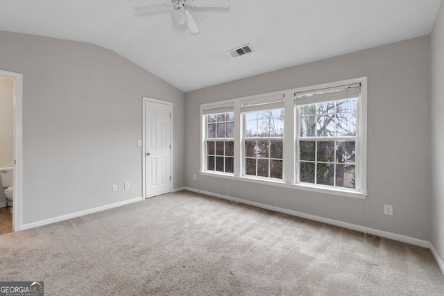 unfurnished bedroom featuring lofted ceiling, light colored carpet, visible vents, ceiling fan, and baseboards