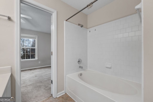 bathroom featuring a textured ceiling, shower / tub combination, vanity, and baseboards