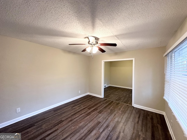 spare room featuring ceiling fan, a textured ceiling, and dark hardwood / wood-style flooring