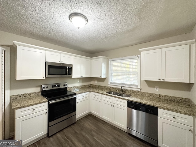 kitchen featuring sink, white cabinetry, appliances with stainless steel finishes, and dark hardwood / wood-style flooring