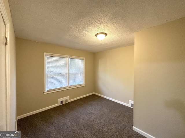 carpeted spare room with a textured ceiling