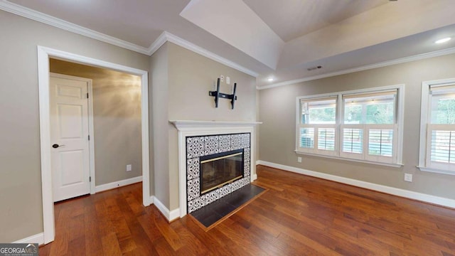 unfurnished living room with a tile fireplace, dark hardwood / wood-style floors, and crown molding