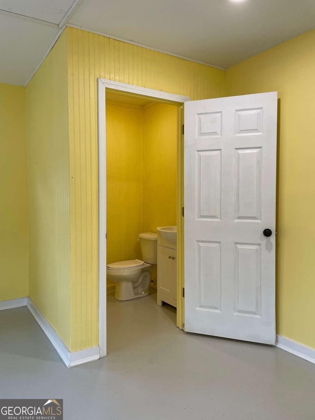 bathroom with concrete floors and toilet