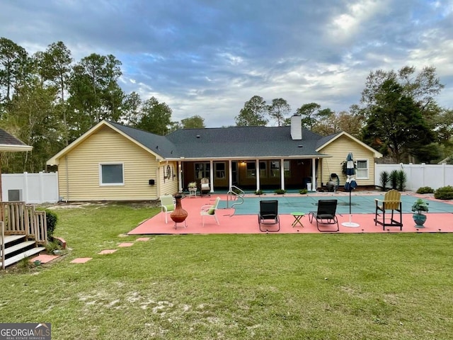 back of property with a lawn and a patio