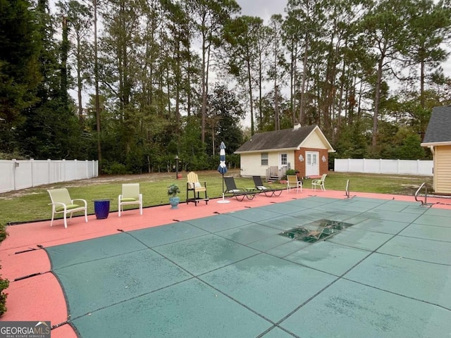 exterior space with a covered pool and a lawn