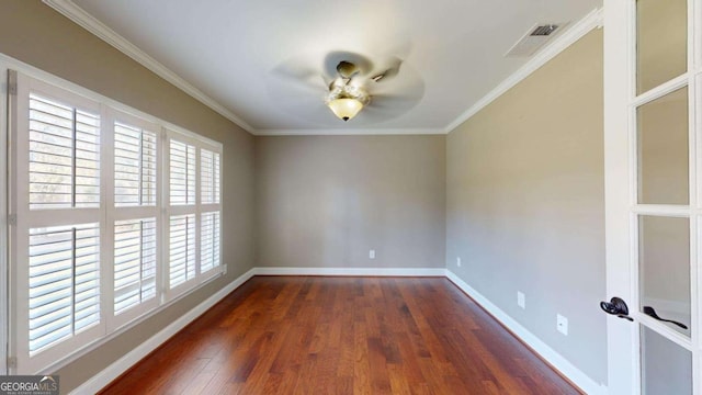 empty room with dark hardwood / wood-style flooring and ornamental molding