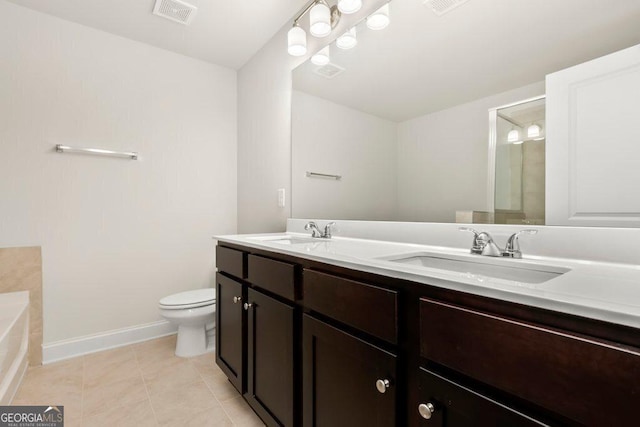 bathroom featuring tile patterned floors, vanity, toilet, and a tub to relax in