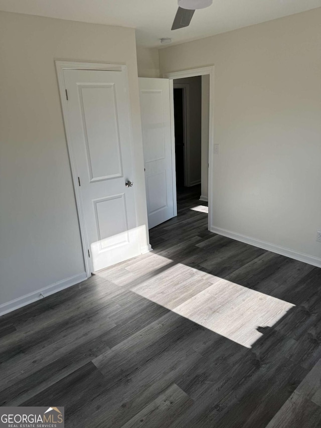 unfurnished room with ceiling fan and dark hardwood / wood-style flooring